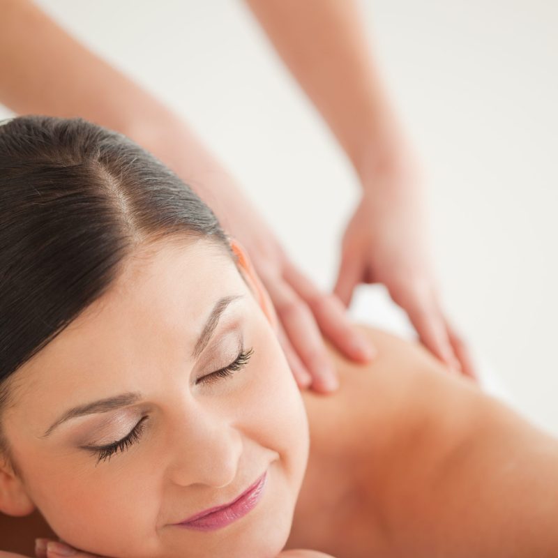 Beautiful dark-haired woman enjoying a massage in a spa centre